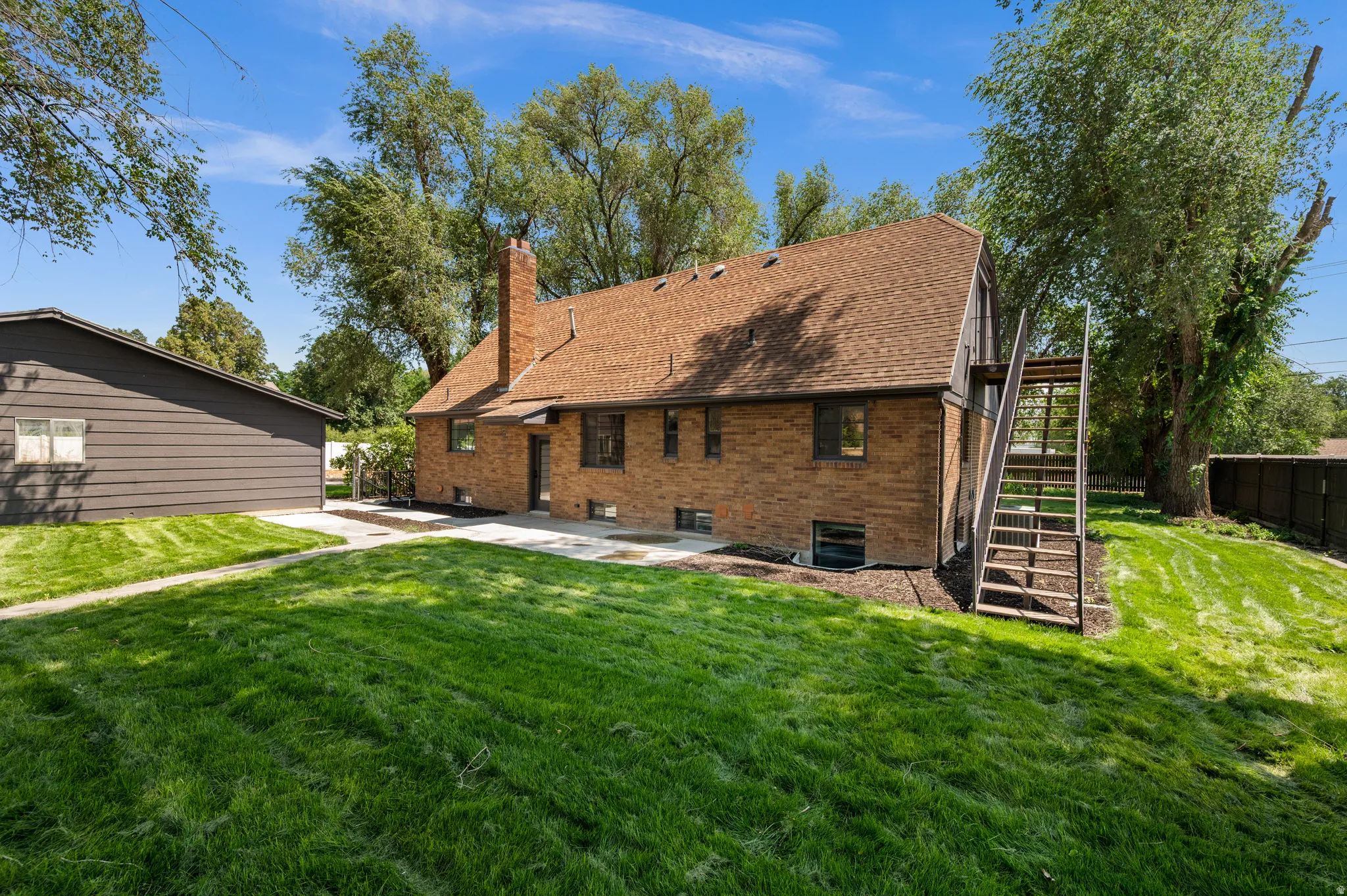 Brick exterior with a shingle roof and a prominent chimney