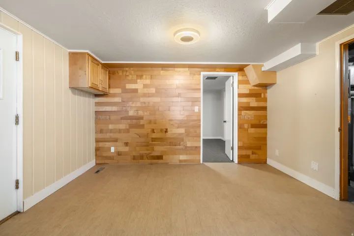 Wood panel wall detailing, built-in overhead cabinetry, and recessed ceiling light fixture