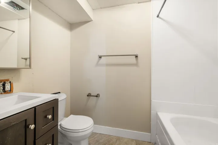 Dark wood-finish vanity with an integrated sink, white countertop, and contemporary hardware