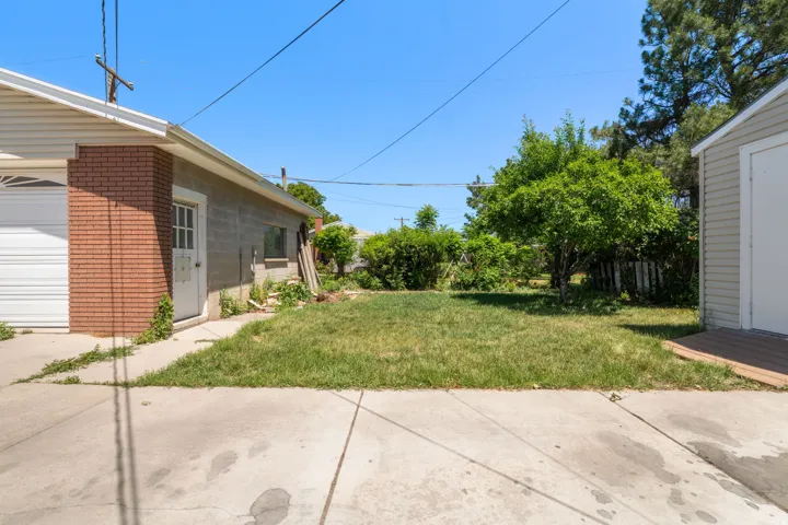 Attached garage with brick column detail, concrete block construction, and a side entry door