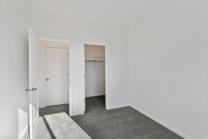 Neutral wall finishes with a single-panel interior door and contrasting knob
