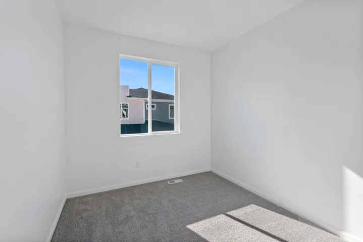 Room featuring white walls, gray carpet, and a white-framed window
