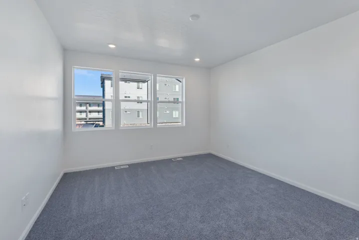 White walls, recessed lighting, and grey carpeting
