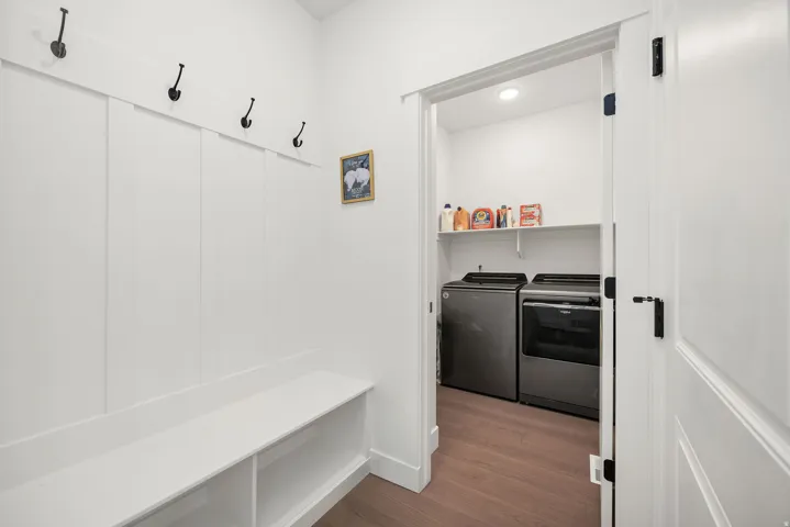 Built-in bench with integrated shelving, wall-mounted coat hooks, and durable wood-finish flooring