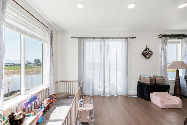 Wood-finish flooring throughout, with white walls and recessed ceiling lighting