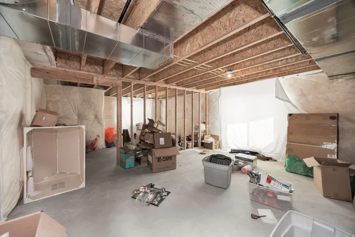 Unfinished basement featuring exposed wood joists, concrete flooring, and metal ductwork