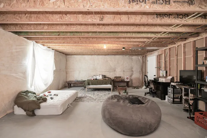 Unfinished basement with exposed ceiling joists, concrete flooring, and partial wall framing