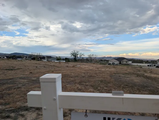 Expansive undeveloped lot featuring natural ground cover and distant mountain ranges