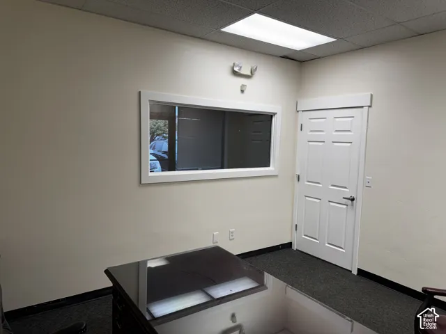 Interior space featuring neutral wall paint, a rectangular interior window with trim, a six-panel door, and recessed lighting