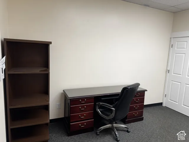 Interior room featuring neutral wall paint, charcoal carpeting, and a six-panel solid core door