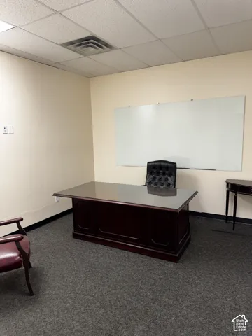 Wall-mounted glass whiteboard, drop ceiling, and neutral wall tones