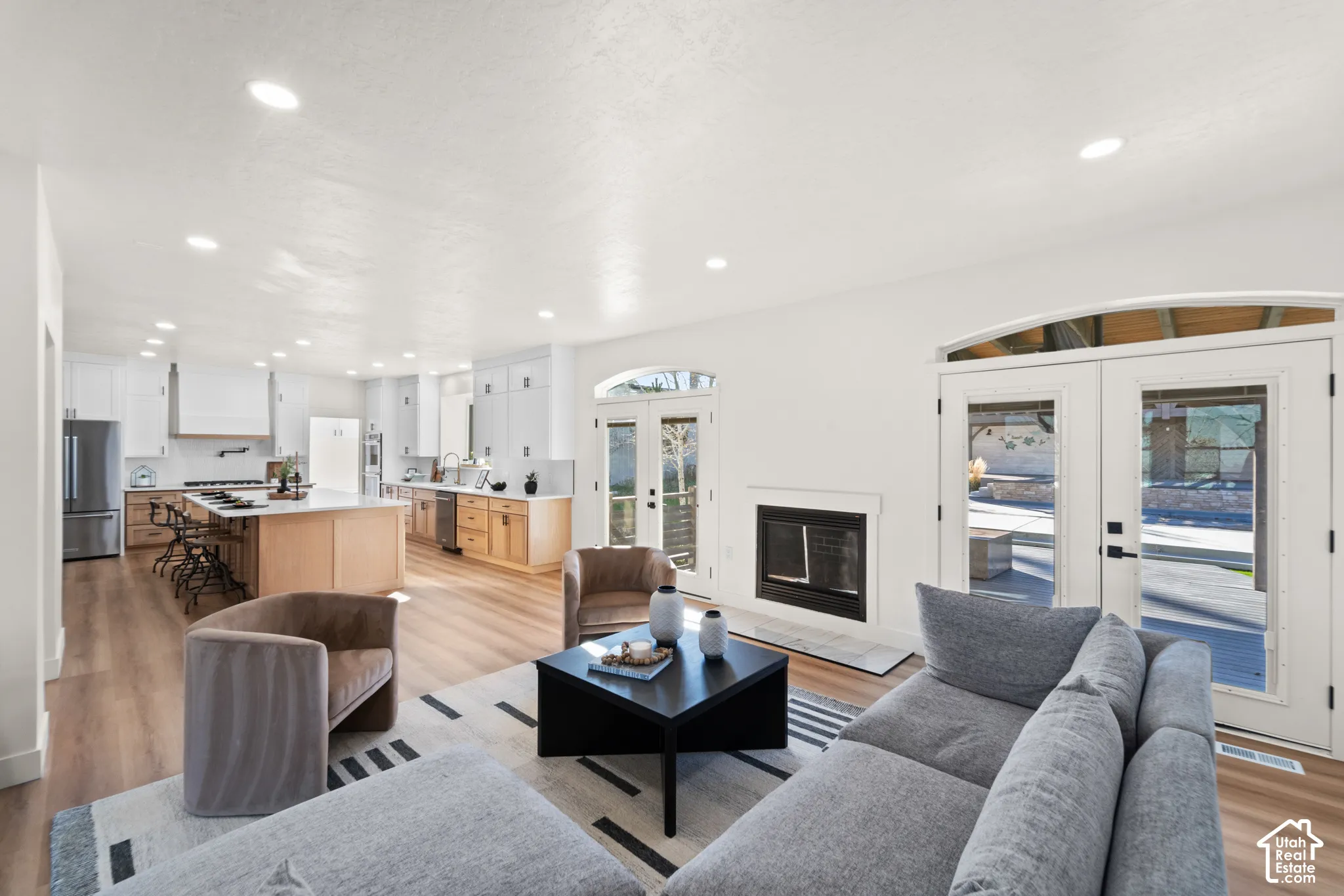 Open concept living area with wood-finish flooring, recessed lighting, and a built-in fireplace