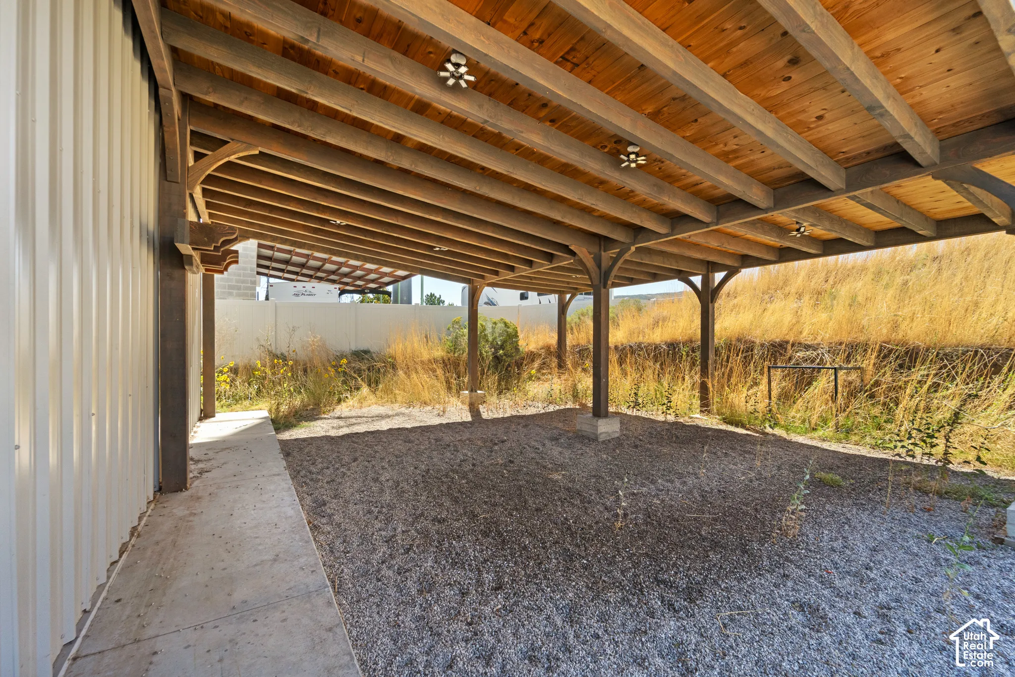 Wood-framed covered area with exposed wood ceiling beams and integrated lighting