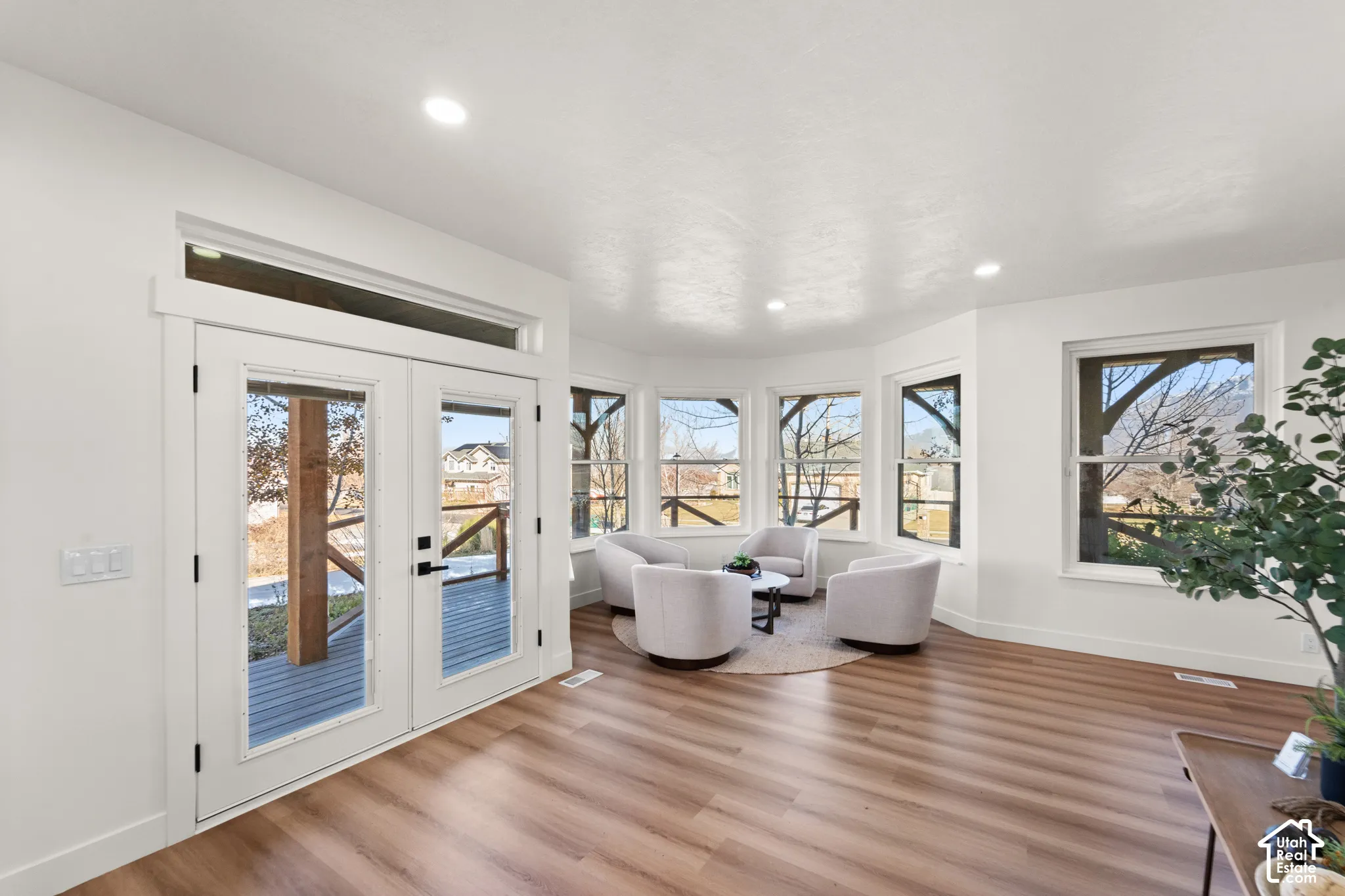 Wood-finish flooring throughout, recessed lighting, and a bay window configuration with multiple windows