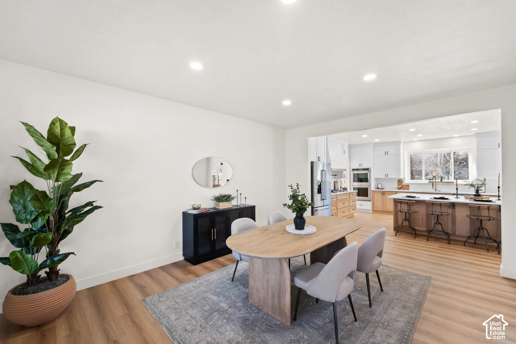 Recessed lighting illuminates the open-concept space featuring wood-finish flooring