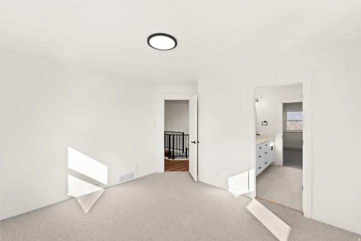 Plush carpet flooring, neutral wall tones, and a contemporary flush-mount ceiling light