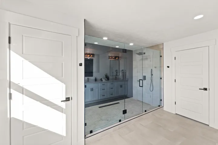 Spacious walk-in shower with clear glass enclosure and overhead rainfall showerhead