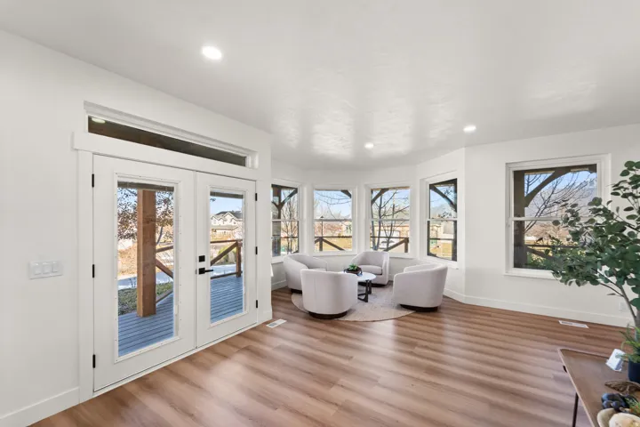 Wood-finish flooring throughout, recessed lighting, and a bay window configuration with multiple windows