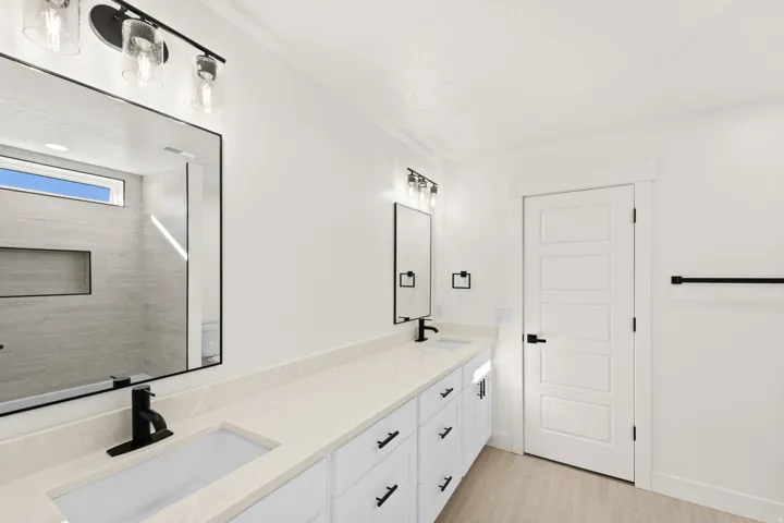 Dual sink vanity with stone-finish countertop, black fixtures, and integrated rectangular sinks