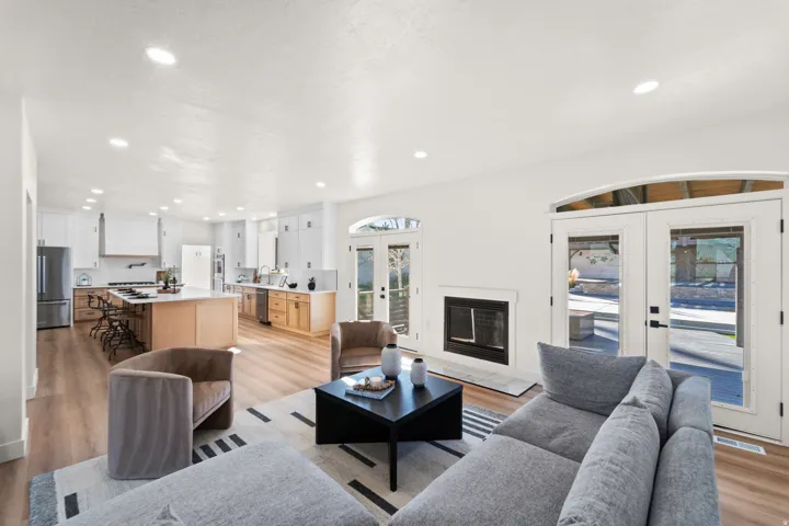 Open concept living area with wood-finish flooring, recessed lighting, and a built-in fireplace