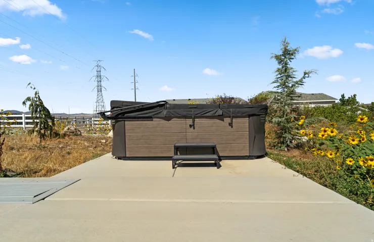 Hot tub with brown wood-finish siding, accompanying steps, and a durable cover