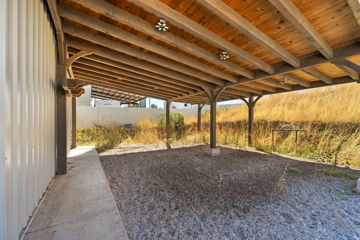 Wood-framed covered area with exposed wood ceiling beams and integrated lighting