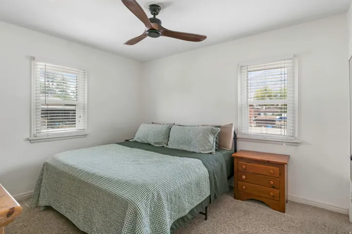 Recessed lighting and ceiling fan complement the bright white walls and neutral-toned carpet