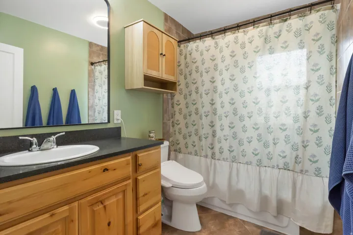 Wood-finish vanity with an integrated sink and chrome faucet