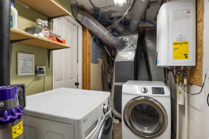 Laundry area featuring a tankless water heater, exposed ductwork, and built-in shelving