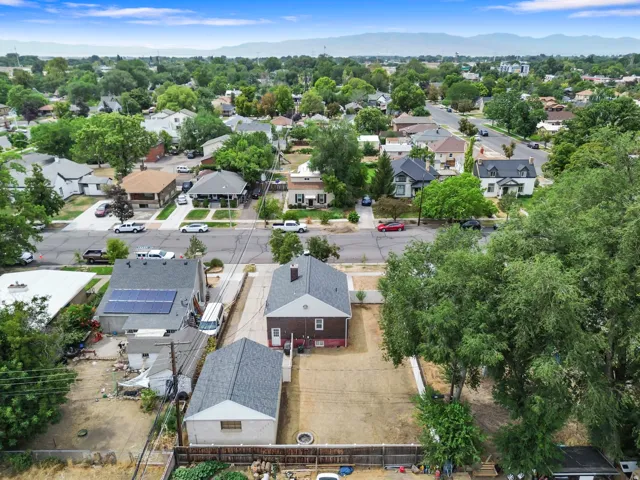 Aerial perspective of a neighborhood with established trees, residential streets, and distant mountains