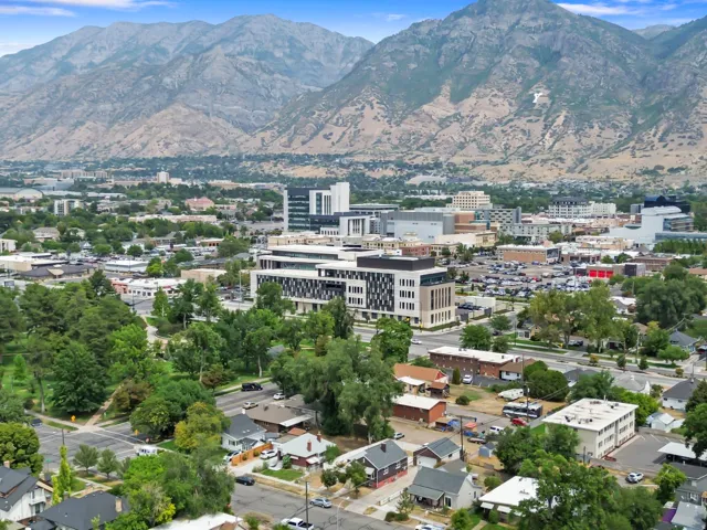 Mountain backdrop, urban area, residential neighborhood, commercial buildings, mature trees