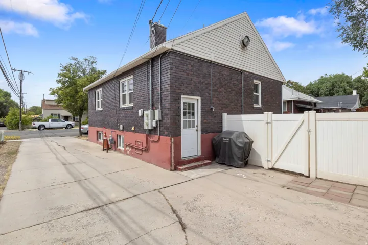 Brick exterior with white trim windows and a white side door