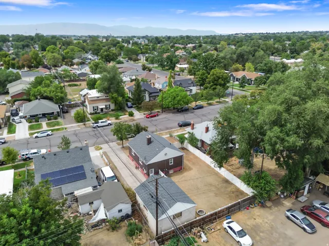 Residential property with a spacious lot, mature trees, and a distant mountain backdrop