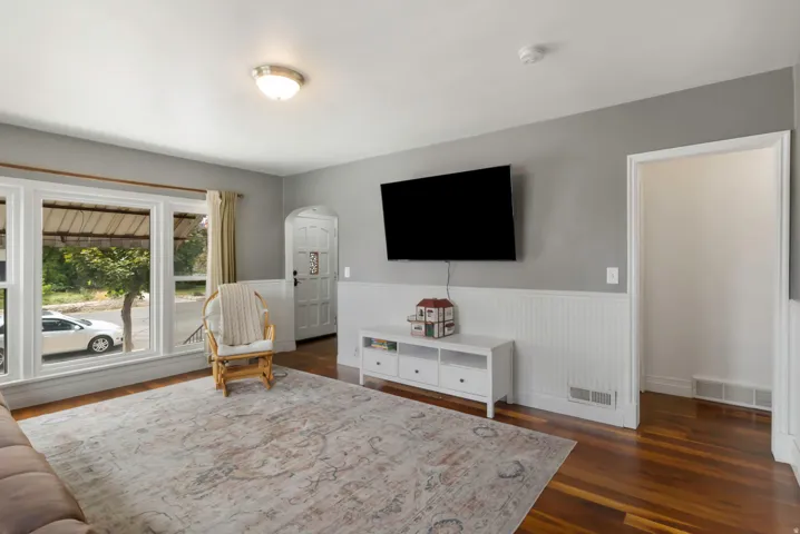 Hardwood flooring, white beadboard wainscoting, multi-pane windows, and a coved entryway
