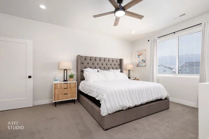 Recessed lighting, ceiling fan with light, broad window with blinds, solid core door with black hardware, and carpeted flooring