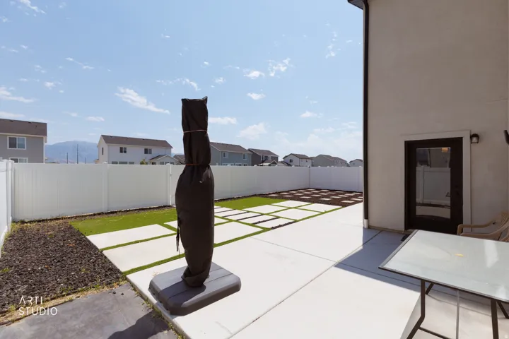 Expansive concrete patio with integrated stepping stones and artificial turf
