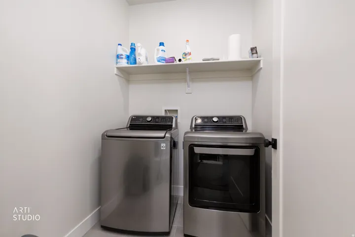Laundry area featuring a wall-mounted shelf and hard-surface flooring