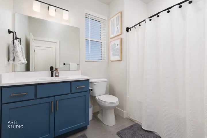 Bathroom featuring a single vanity with blue cabinetry, white countertop, and a rectangular undermount sink