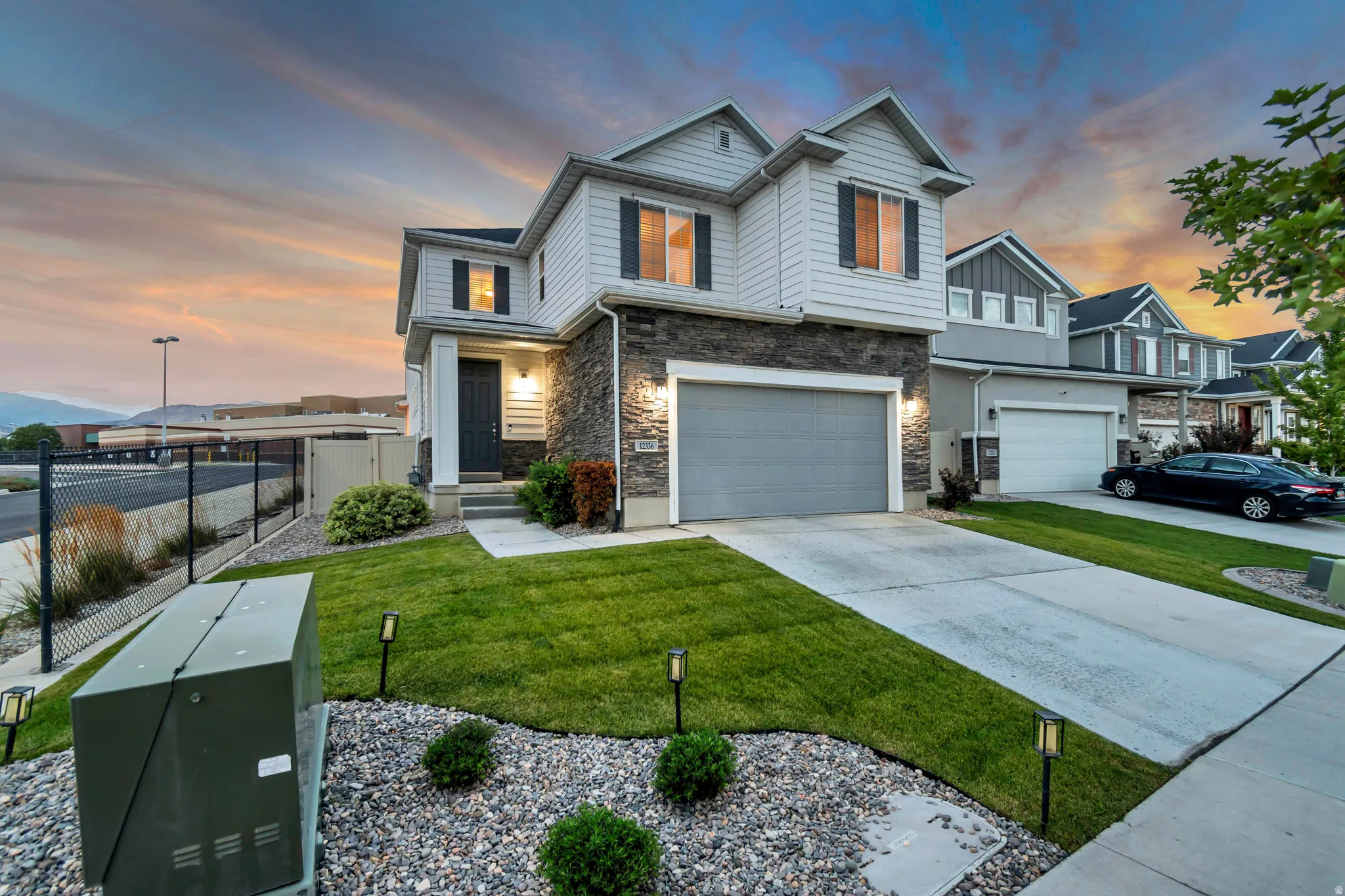 Two-story residence featuring light-colored siding and stone accents
