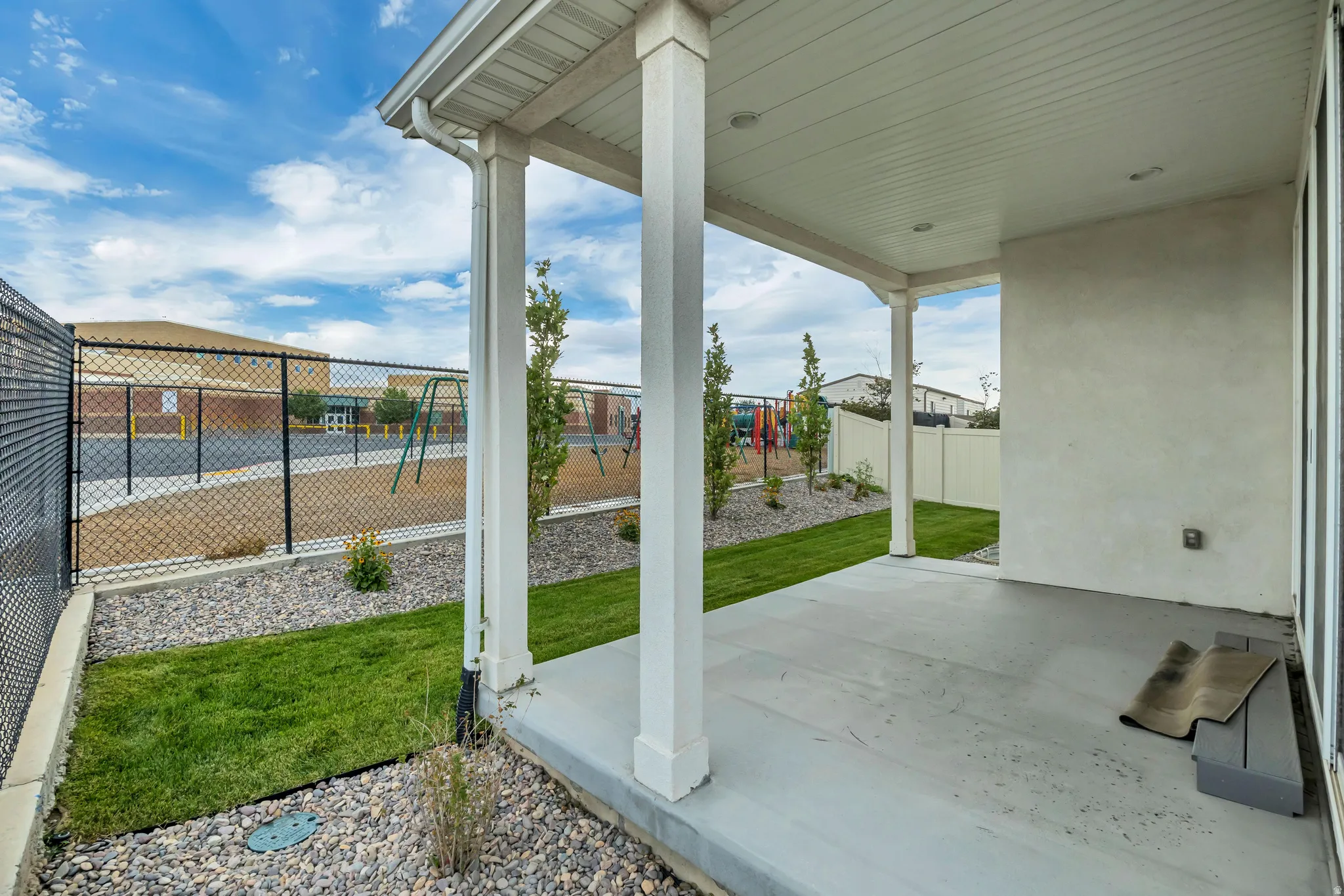 Covered patio with a concrete surface, supported by white columns