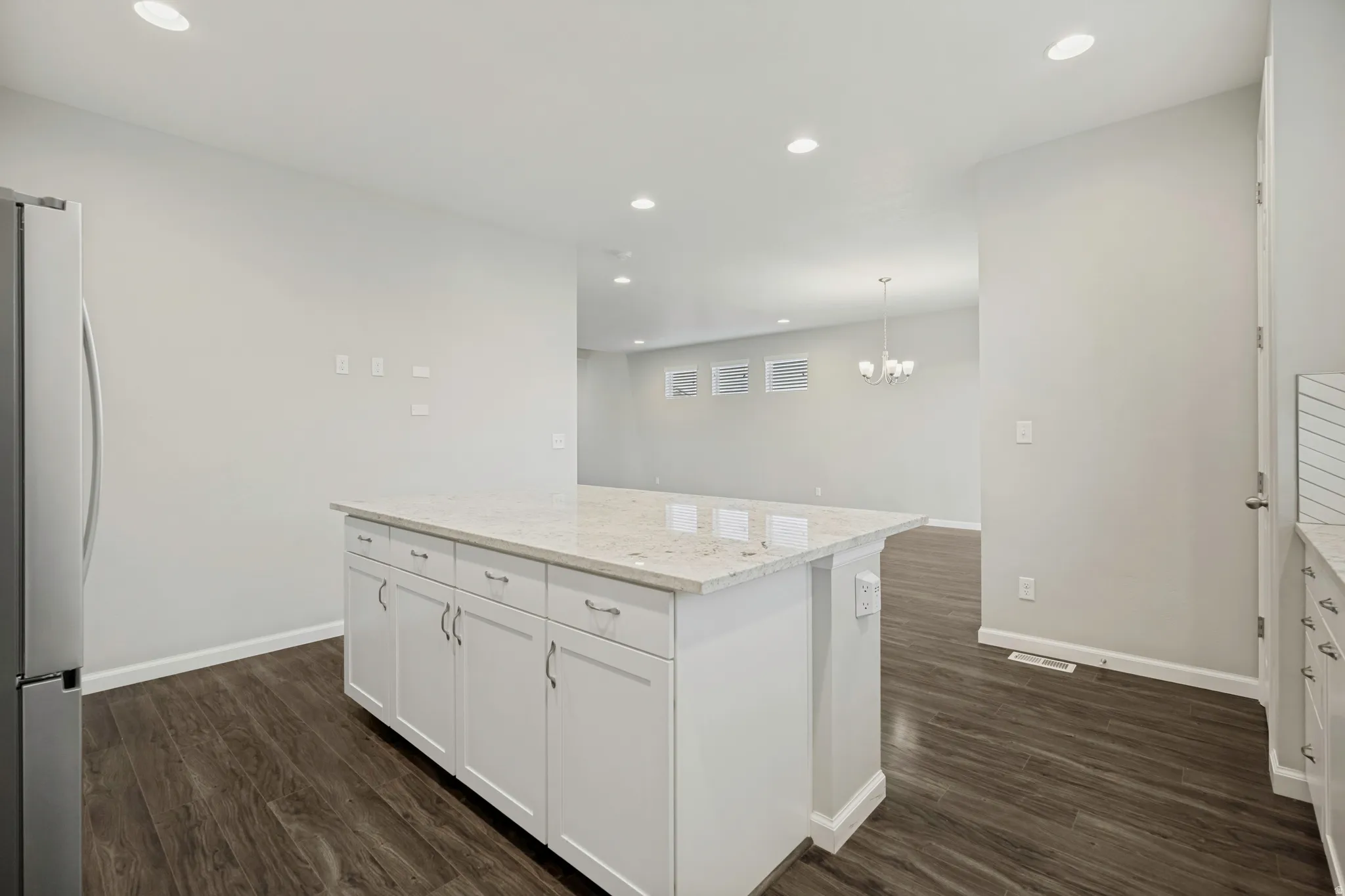 Kitchen island featuring a light-toned countertop and white cabinetry