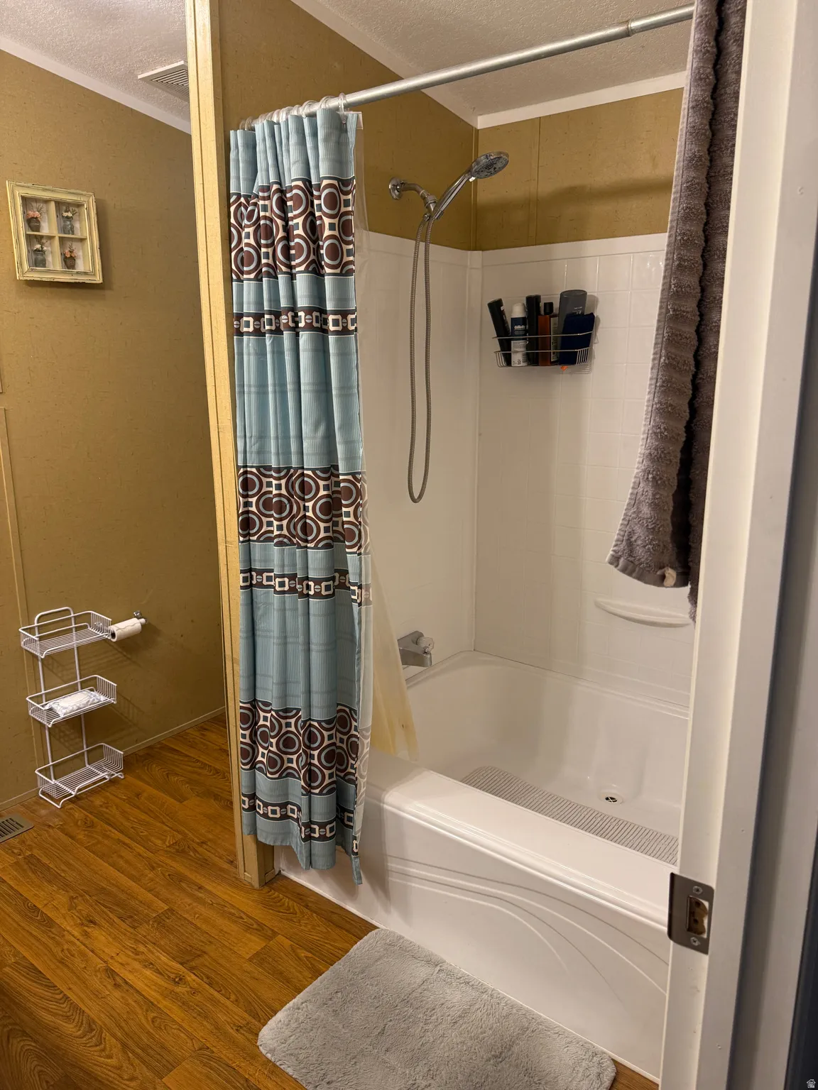 White bathtub and shower combination with a handheld showerhead