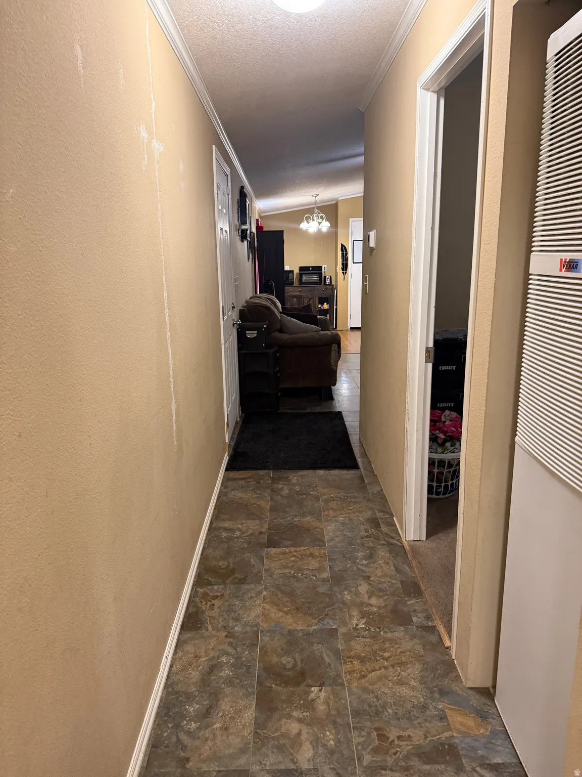 Hallway with tiled flooring and crown molding