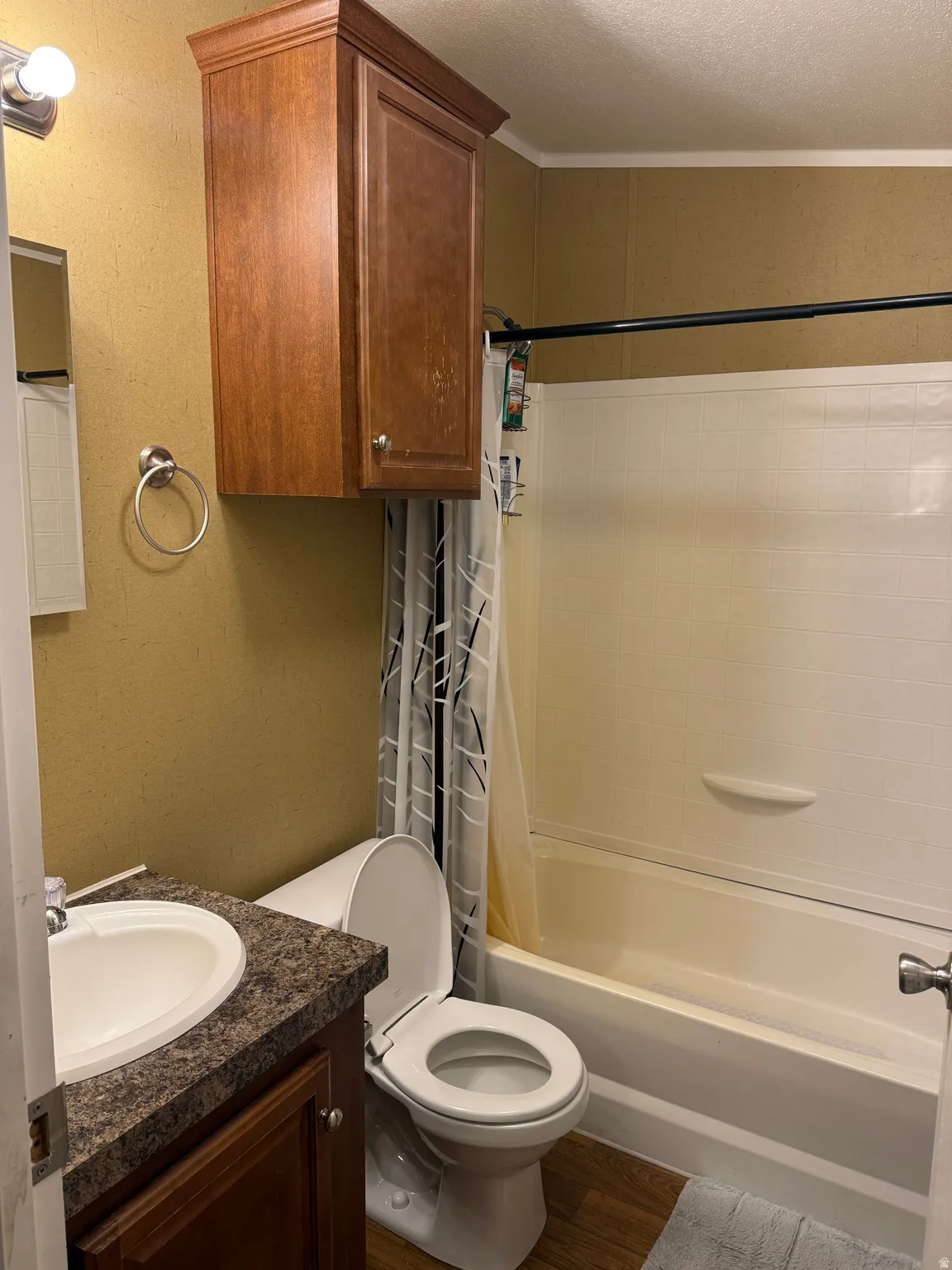 Built-in wood-finish cabinetry, bathtub with shower fixture, wood-finish flooring, and vanity with integrated sink