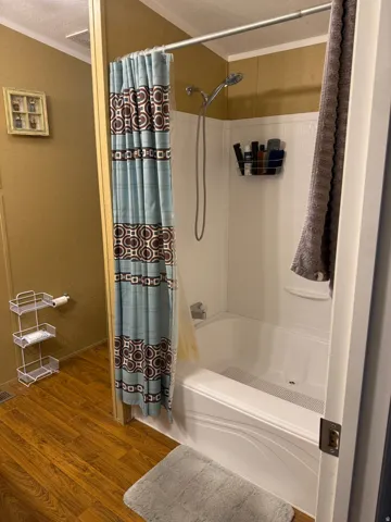 White bathtub and shower combination with a handheld showerhead