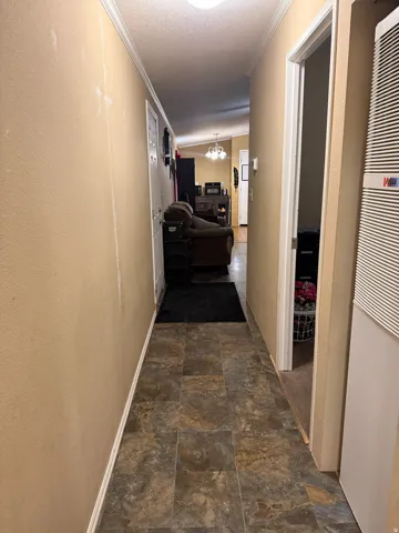 Hallway with tiled flooring and crown molding