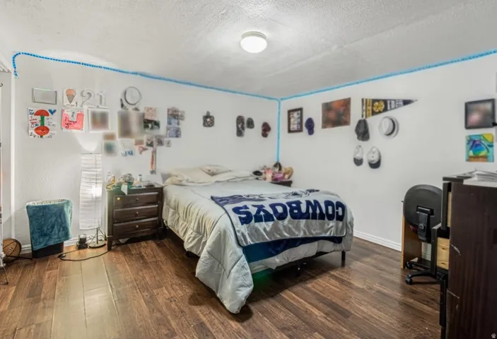 Room featuring wood-finish flooring, white walls, and a recessed ceiling light fixture