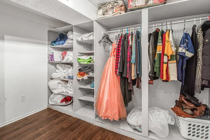 Built-in shelving units with hanging rods and wood-finish flooring