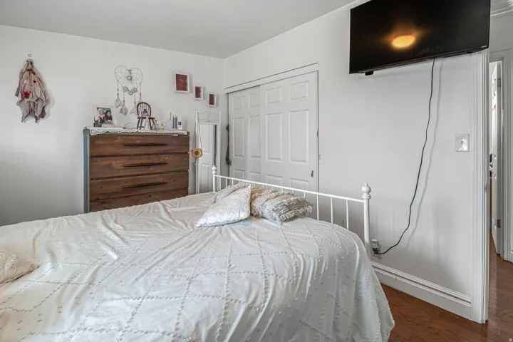 Room featuring hard surface flooring, white walls, and a built-in closet with bi-fold doors