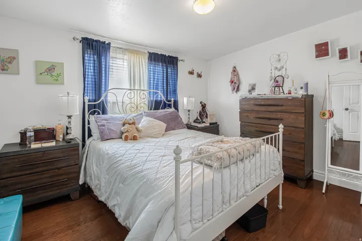 Hardwood flooring throughout, white walls, and a ceiling-mounted light fixture